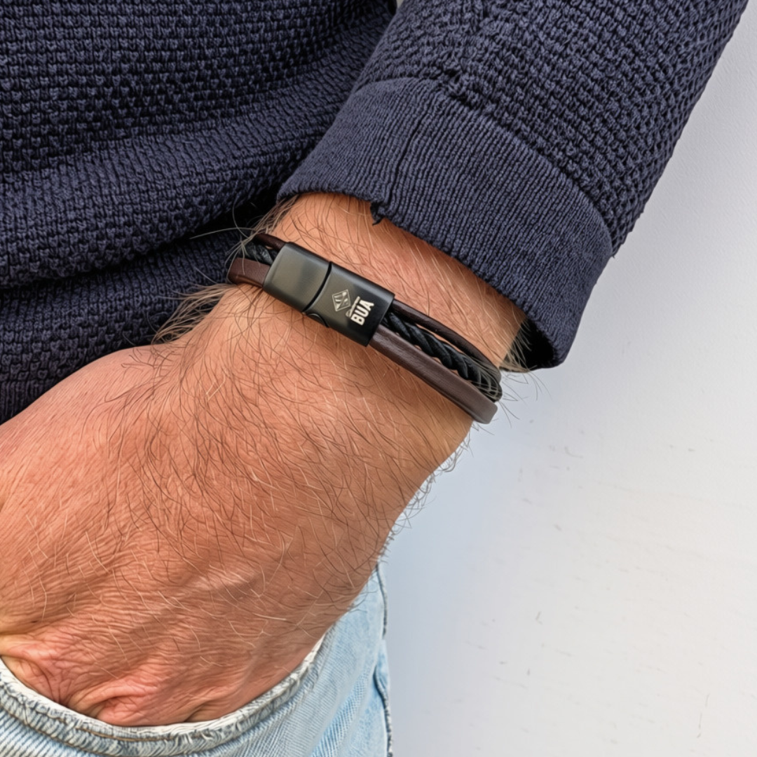 Bavarian BUA Armband Trio in Braun-Schwarz, mit drei Strängen aus Leder und Textil, am Handgelenk zu dunkelblauem Strickpullover.