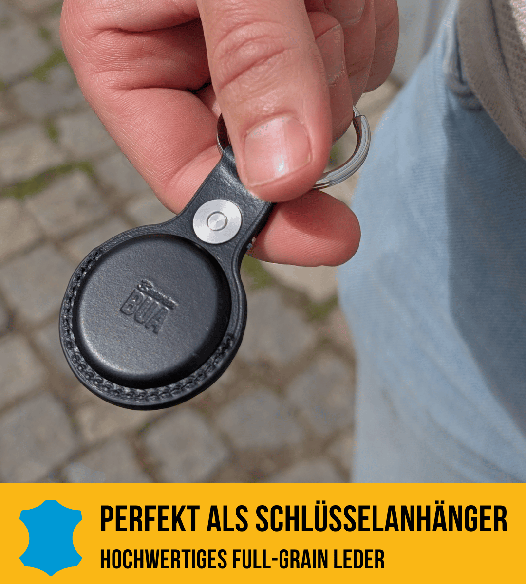 Airtag Hülle in schwarzem Leder, dargestellt auf in der Hand.
