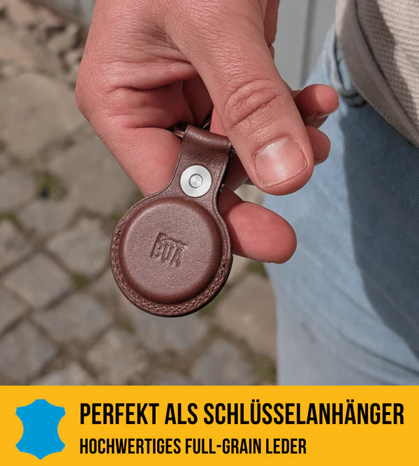 Airtag Hülle in braunem Leder, in der Hand.