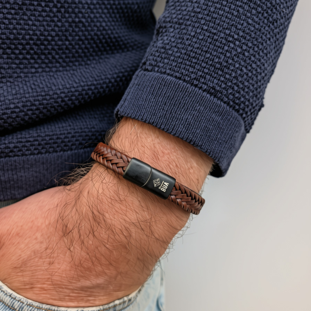 Bavarian BUA Armband Flecht in Braun, breit geflochten, am Handgelenk zu dunkelblauem Strickpullover.