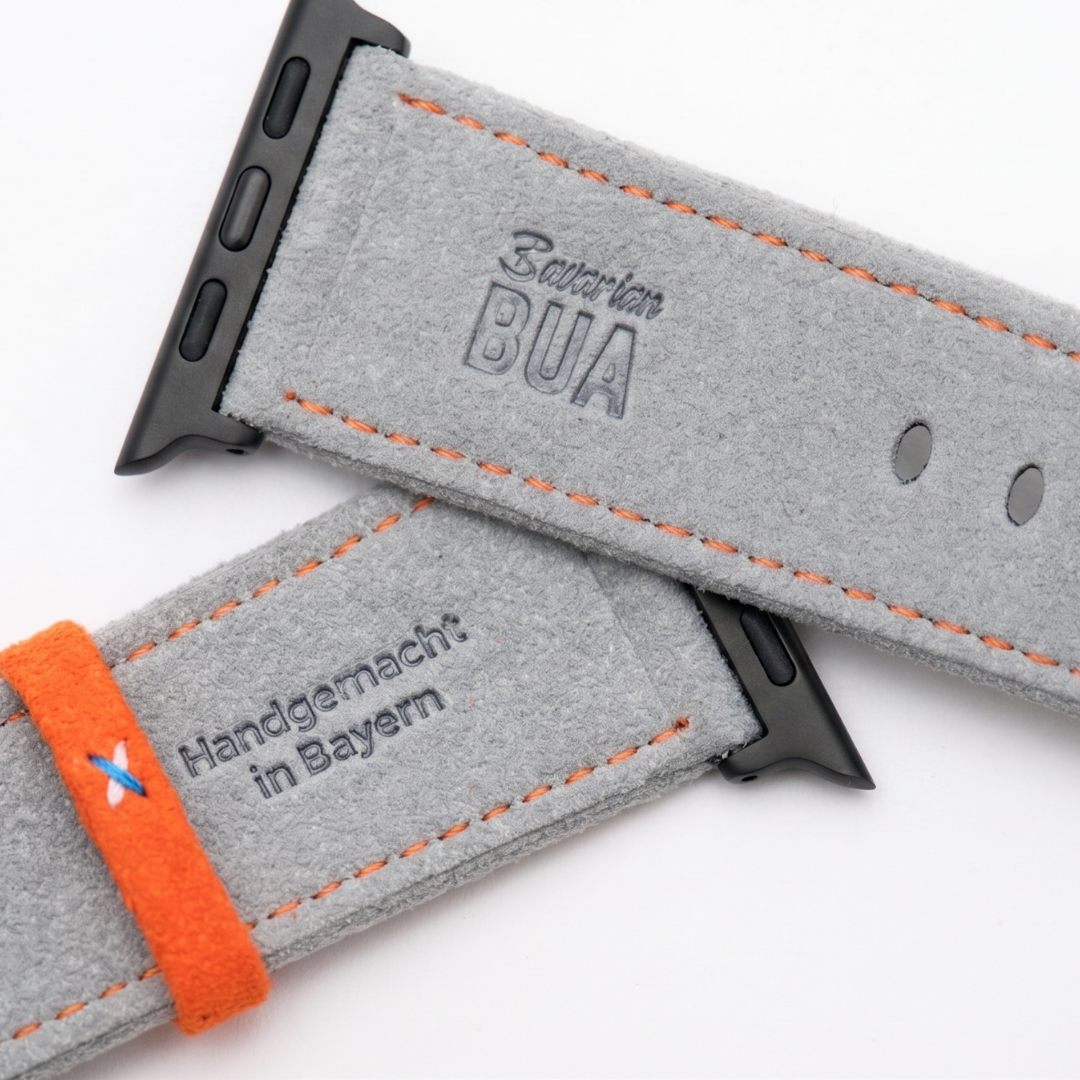 Graues Alcantara Armband für Apple Watch Ultra mit orangefarbenen Nähten, Edelstahl-Adapter und handgemachter Prägung aus Bayern